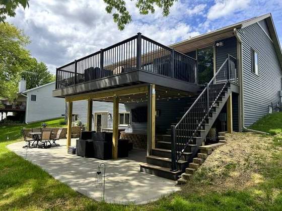 Two-level composite deck with black aluminum rail over a covered patio