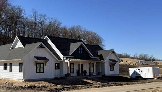 Modern farmhouse nearing completion with the Elite Home Solutions trailer on site